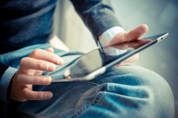 close up hands multitasking man using tablet, laptop and cellhpo close up hands multitasking man using tablet, laptop and cellhpone connecting wifi